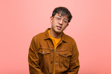 Young chinese man wearing a jacket cheerful with a big smile