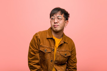 Obraz premium Young chinese man wearing a jacket dreaming of achieving goals and purposes