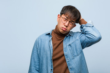 Young chinese man worried and overwhelmed