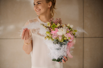 Portrait of a girl with bouquet with decorative feathers