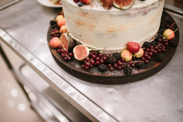 Big white wedding cake with fruit is on the table