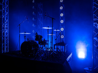 Drum set on the stage of a concert hall or club in a beautiful bright light. Drum set at a rock concert