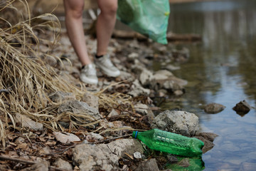woman picking up dump on dirty forest