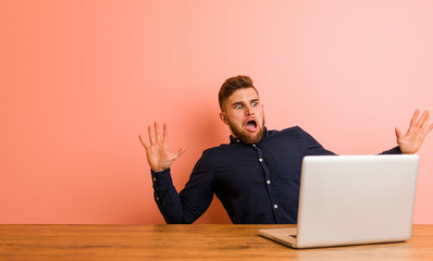 Young man working with his laptop being shocked due to an imminent danger