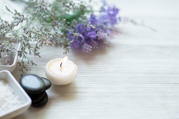 Obraz na płótnie Canvas Spa setting relax composition burning candles and lavender flowers with hot stone on white wooden background ,wellness healthy concept