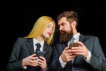 Business partner discuss about detail on smartphone. Man shows woman information on smartphone screen. Teamwork. Businesspeople. Business, technology, communication. Business people using smart phones