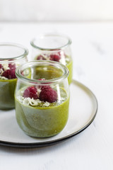 White chocolate cream mousse with matcha, avocado, pistachio, fresh raspberries - healthy vegan dairy free, gluten free