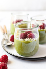 White chocolate cream mousse with matcha, avocado, pistachio, fresh raspberries - healthy vegan dairy free, gluten free