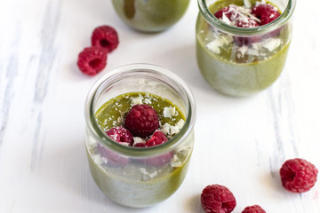 White chocolate cream mousse with matcha, avocado, pistachio, fresh raspberries - healthy vegan dairy free, gluten free