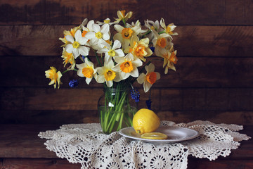 bouquet of yellow garden daffodils and lemon, still life with spring flowers © Masquerade
