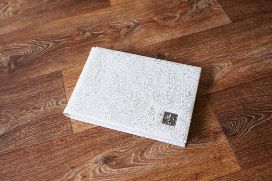 Photo book with a cover of genuine leather. White color with decorative stamping. Close up picture