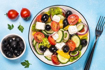 Greek salad on blue table.