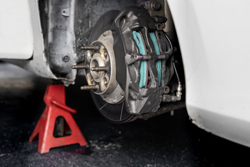 Maintenance car. Jacking up a car for changing tire in garage.