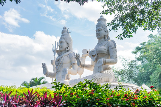 lord shiv & parvati statue at an indian garden looking awesome with small shrubs.