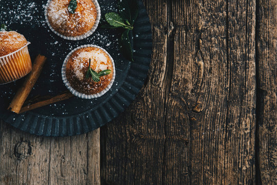 Home-baked muffins with cinnamon and mint on plate