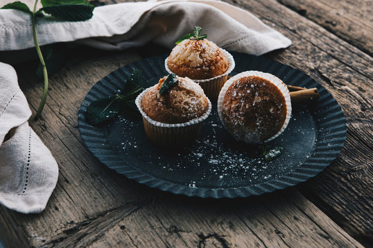Home-baked muffins with cinnamon and mint on plate