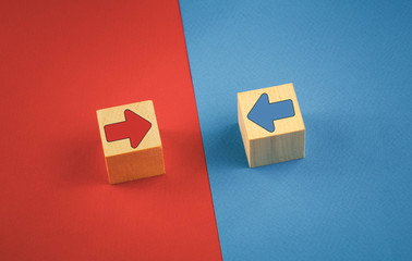 two wooden cubes with red and blue arrows on a red-blue background.