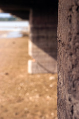 closeup of pier and sand by beach