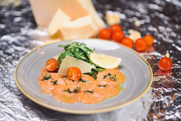 salmon carpaccio with parmesan, cherry tomatoes and arugula