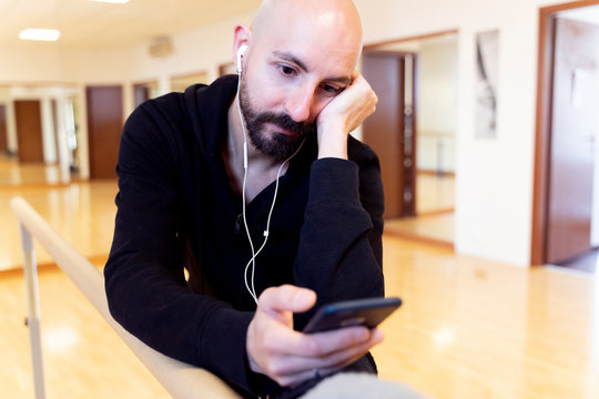 Ballet dancer using cell phone in ballet studio