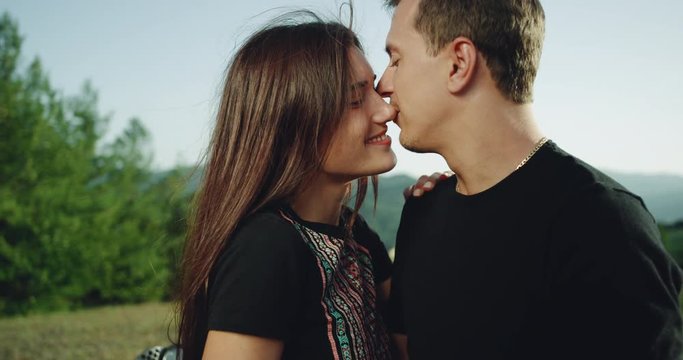 Portrait of a young couple touching romantic each other in amazing landscape place beside of their motorcycle