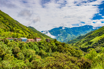 Naklejka premium South America. Ecuador. Separately located village at the height of the Andes. Andes mountains greenery covered with cloudy tops. Mountain landscape of Ecuador. Tours to Ecuador.