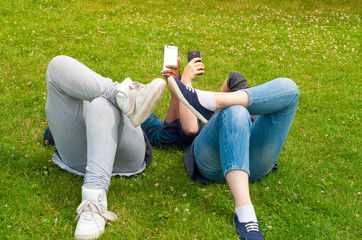 Teenage girls using mobile smart phones outdoor