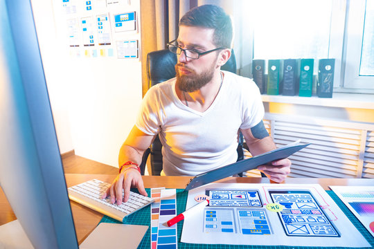 Ux ui design concept. The designer compares the paper layout of the mobile application with the web prototype. Prototyping software. Select the mobile application interface. Wireframing.