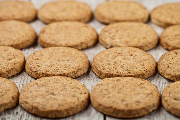 Fresh baked oat cookies closeup on rustic wooden table background.