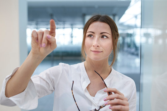 Young businesswoman touching virtual touchscreen