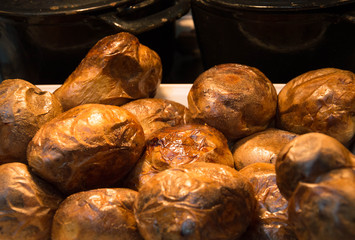 Baked jacket potatoes under a heat lamp