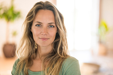 Portrait of smiling blond woman at home