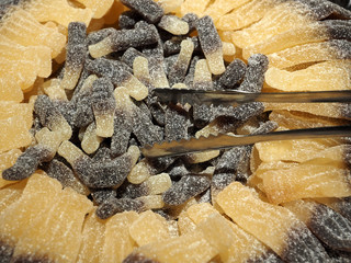 cola bottles at a sweets shop with a food pliers
