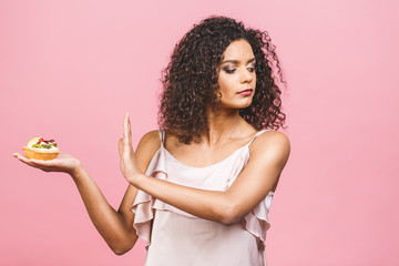 American afro girl does not eat cake. Conception to lose weight. Hand gesturing no to a cake....