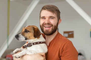Animal, pet and people concept - Handsome man and domestic jack russell terrier dog pose together...