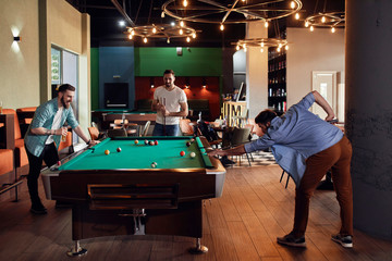 Friends playing billiards together