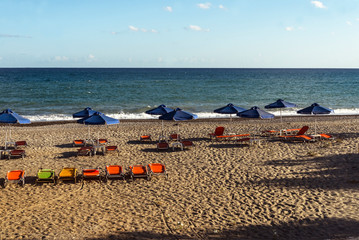 Cretan beach in summer with umbrellas and sun beds