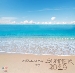 Fototapeta na wymiar welcome to summer 2019 written on a tropical beach