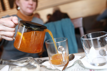 Woman pouring sea buckthorn tea