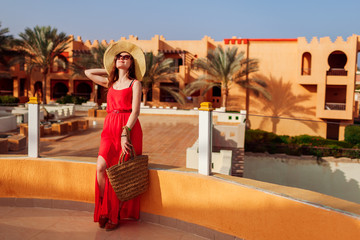 Fototapeta na wymiar Young woman walking on hotel territory. Summer vacation in Egypt. Stylish fashionable look