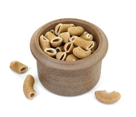 Rustic rigatoni pasta isolated in a clay bowl on white background. Maccheroni integrals pasta. Wholemeal Pasta. Close-up on a Integral Penne.