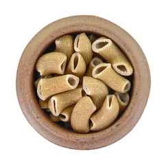 Rustic rigatoni pasta isolated in a clay bowl on white background. Maccheroni integrals pasta. Wholemeal Pasta. Close-up on a Integral Penne.