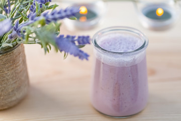 Yogurt with blueberries. Homemade yogurt with blueberry in jars in a garden in summertime. Evening light. Bouquet of lavender. Blurry background. Soft focus. Closeup. Macro.
