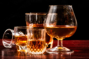 Brandy or liquor,Set of strong alcoholic drinks in glasses and shot glass on dark wood background