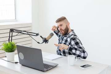 Radio host, streamer and blogger concept - Handsome man working as radio host at radio station...
