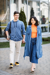 Young cute couple - a boy and a girl walking around the city and photographed. A couple have fun spending time together. Date two nice people in the park