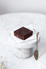 Vegan raw brownies with nuts and dates, on white marble background with copy space. Healthy dessert concept