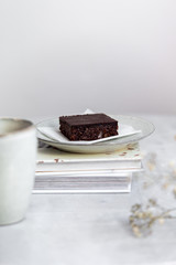 Vegan raw brownies with nuts and dates, on white marble background with copy space. Healthy dessert concept