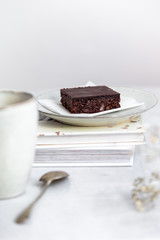 Vegan raw brownies with nuts and dates, on white marble background with copy space. Healthy dessert concept