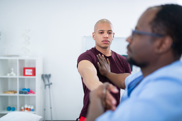 Young bodybuilder feeling worried having physical examination